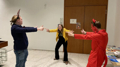 Drei als Teufel verkleidete Menschen stellen das Spiderman-Meme nach.