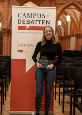 Chiara Throner mit ihrem Glaspokal vor dem VDCH-Banner